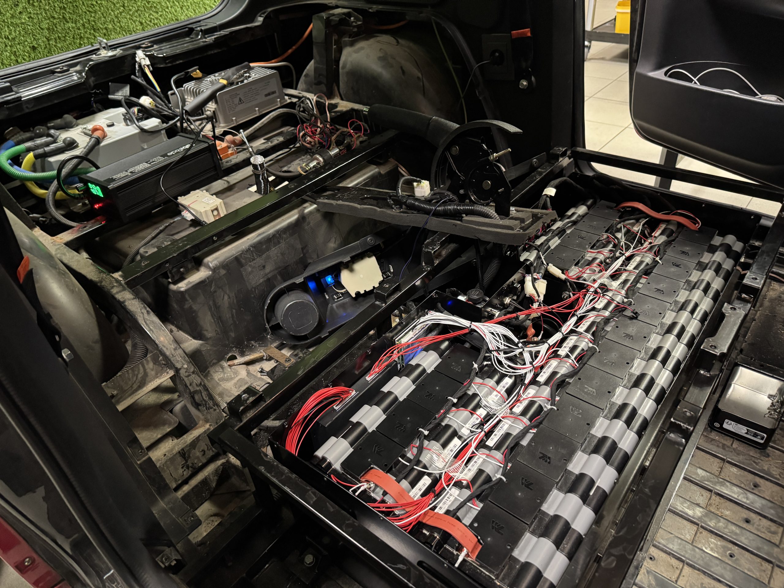 Measuring EV battery cell voltages during diagnostics in the FabiRide workshop in Kaunas